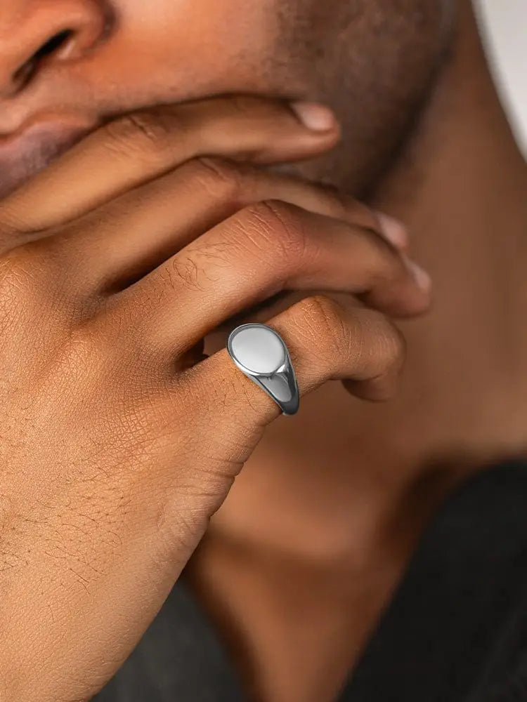 Polished silver oval signet ring with a smooth face and sleek band made of 316l stainless steel