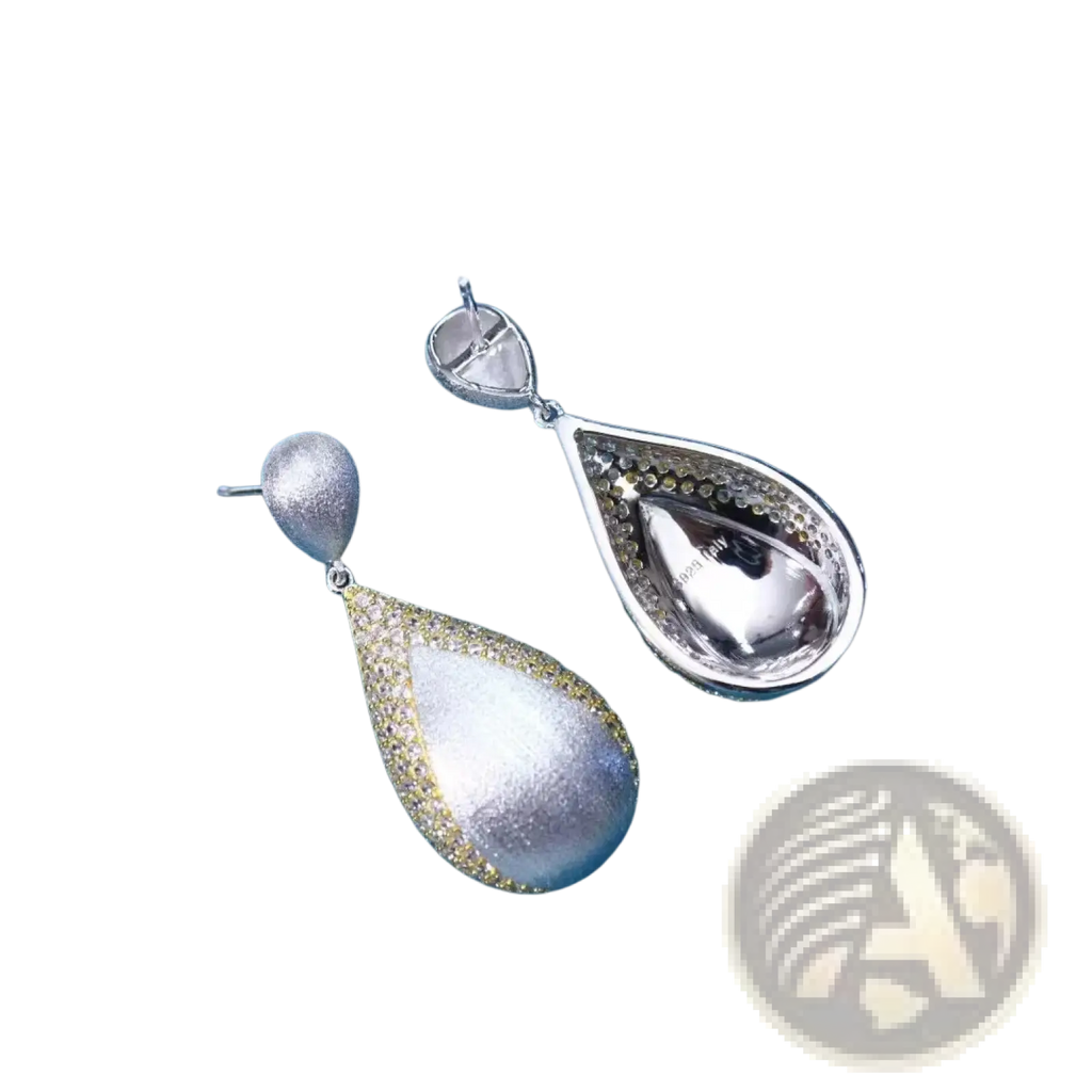 Silver teardrop tassel earrings with shimmering textured silver surface and delicate gold vermeil detailing