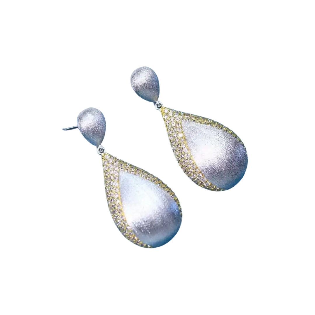Silver teardrop tassel earrings with gold vermeil, textured matte finish, and pavé diamond edge detailing