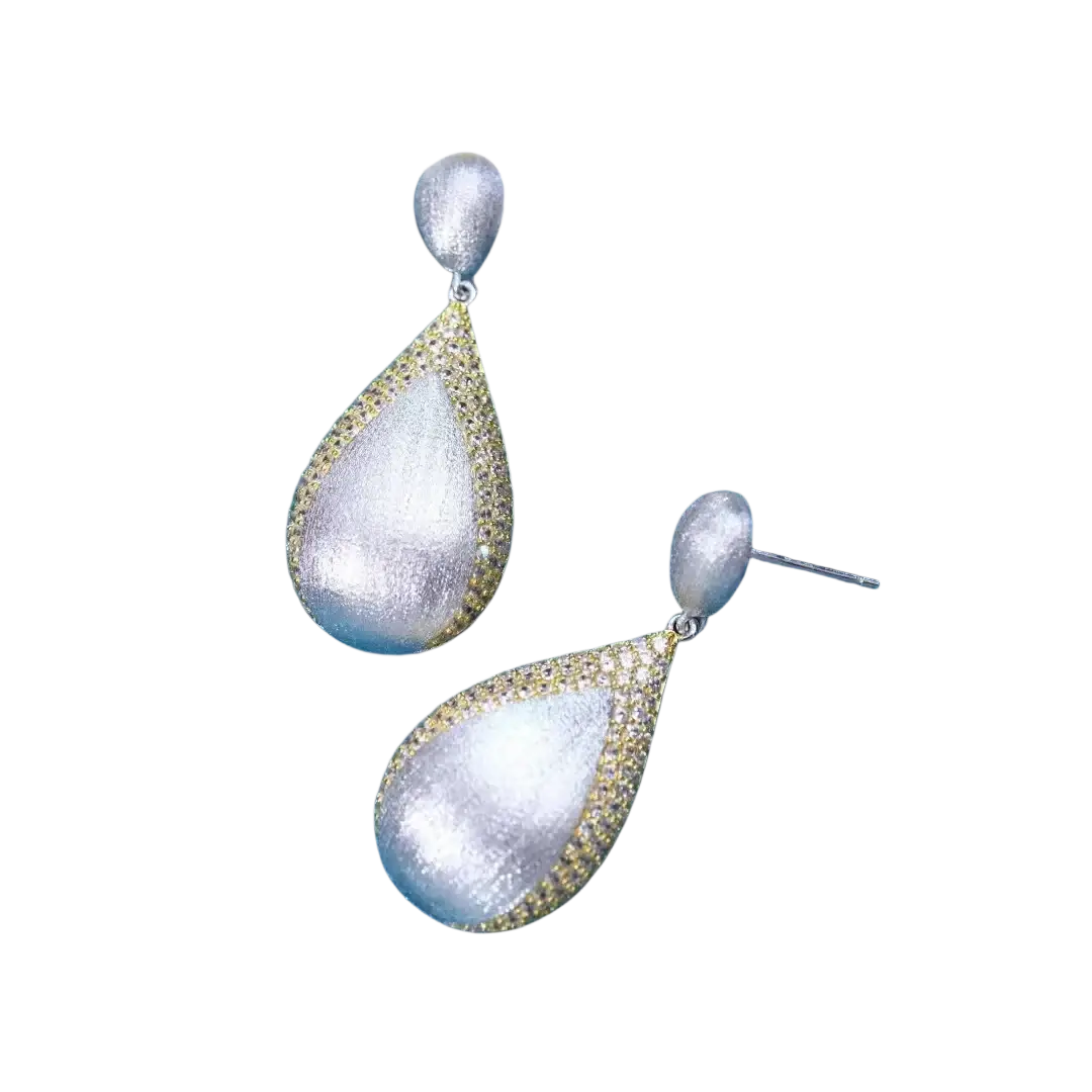 Silver teardrop tassel earrings with a textured matte finish and gold vermeil pavé detailing along the edges