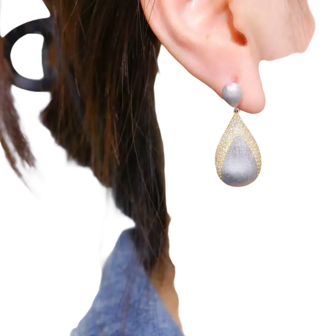 Silver teardrop tassel earring with textured glittering surface and gold vermeil边镶边 detailing