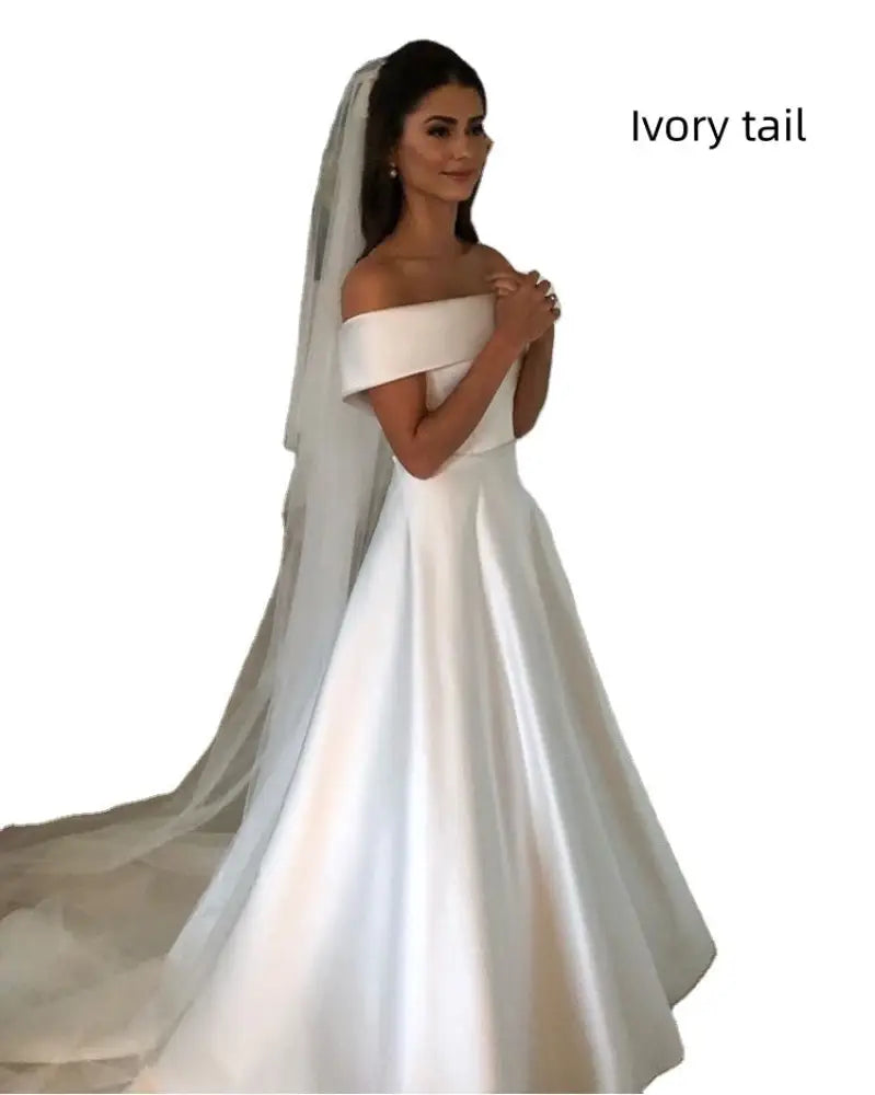 Ivory satin off the shoulder a line wedding gown with a sweep train and matching veil shown from the back side