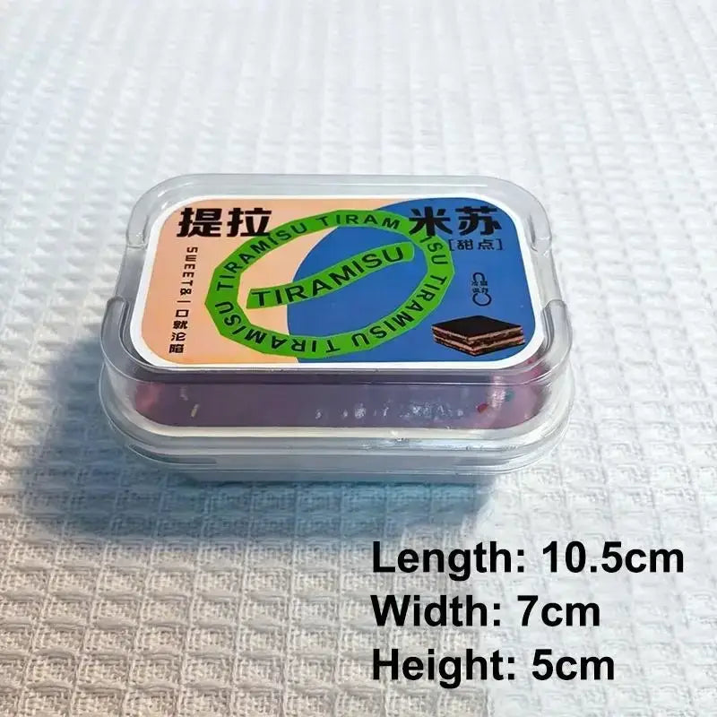 A clear plastic container holding a miniature tiramisu simulated ice cream cake slow rising fidget toy with colorful branding and chinese characters