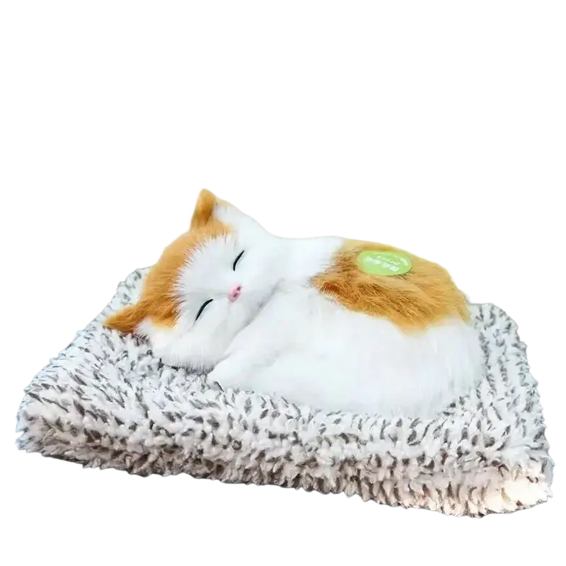 A plush calico cat sleeping figurine with white and orange fur resting on a textured gray and white fuzzy cushion