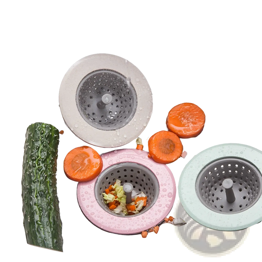 Three colorful silicone sink strainers in gray pink and mint green with perforated metal centers for anti clogging kitchen use