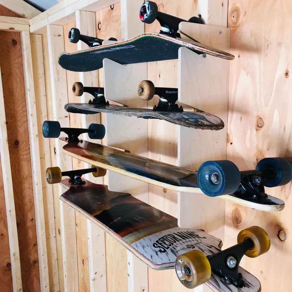 Vertical wooden skateboard wall mount storage rack holding five skateboards with varied deck designs and colored wheels