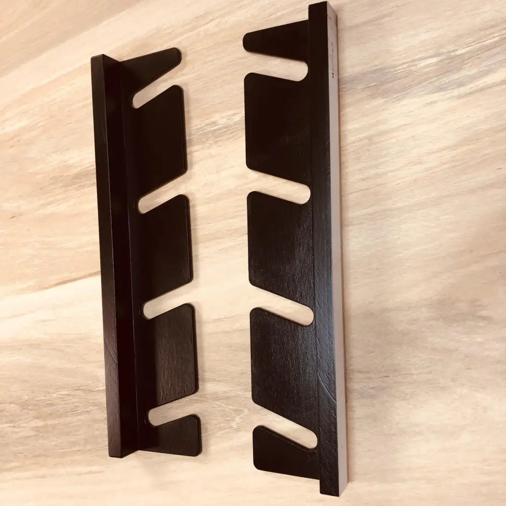 Black wooden multi deck vertical skateboard and snowboard wall rack with sleek minimalist design and evenly spaced card slots