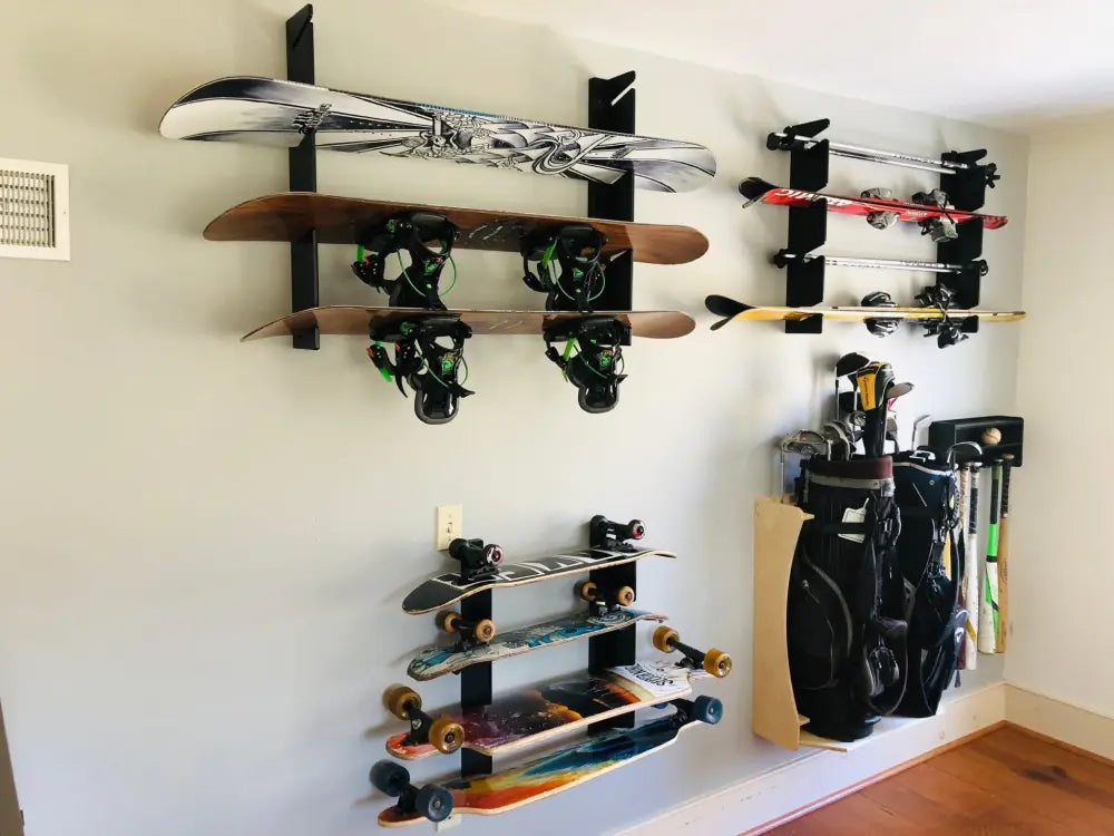 Black metal wall-mounted multi deck vertical skateboard and snowboard rack holding multiple skis and snowboards