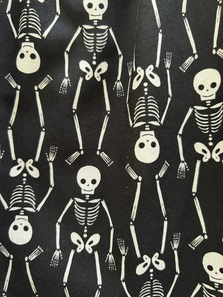 Black cotton a-line dress with pockets featuring a retro white cartoon skeleton print pattern on fabric