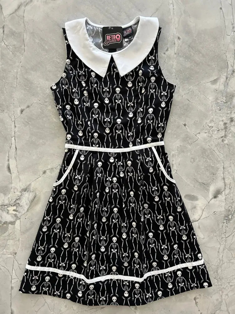 Black sleeveless retro skeleton print cotton A-line dress with white peter pan collar and trim featuring pockets
