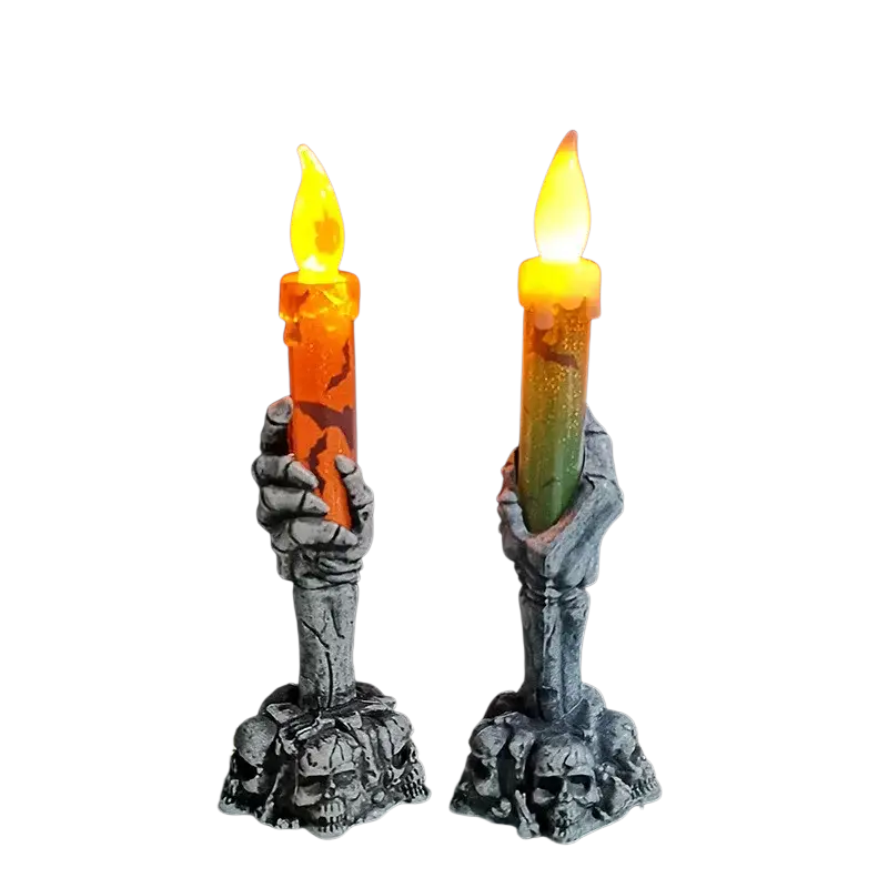 Two gray skeleton hand led candle holders gripping glowing orange and green candles for happy halloween party decor