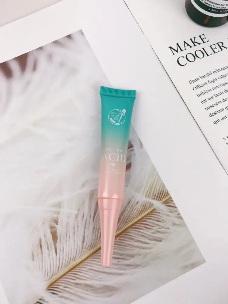 A gradient teal to pink squeeze tube of hyaluronic acid facial serum with metallic cap for hydrating glowing skin