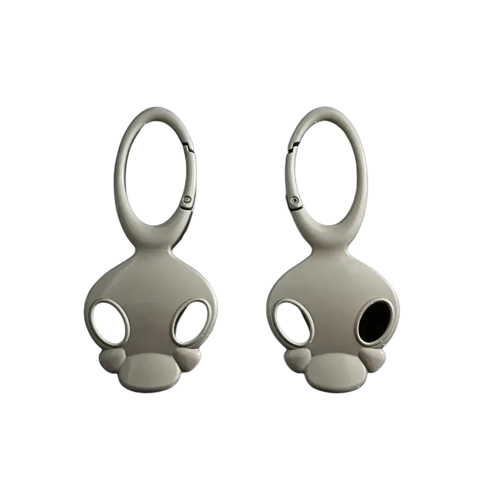 A pair of sleek matte white skull metal car keychains with black eye cutouts and smooth metallic loops for bags and keys