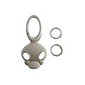Silver-colored glossy metal skull keychain with stylized cartoon head design for car keys or bag charm