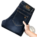 Back side of slim fit dark blue denim jeans men with gold-tone bee emblem on back pocket and waistband patch