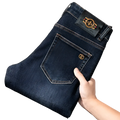 Back side of slim fit dark blue denim jeans men with gold-tone bee emblem on back pocket and waistband patch