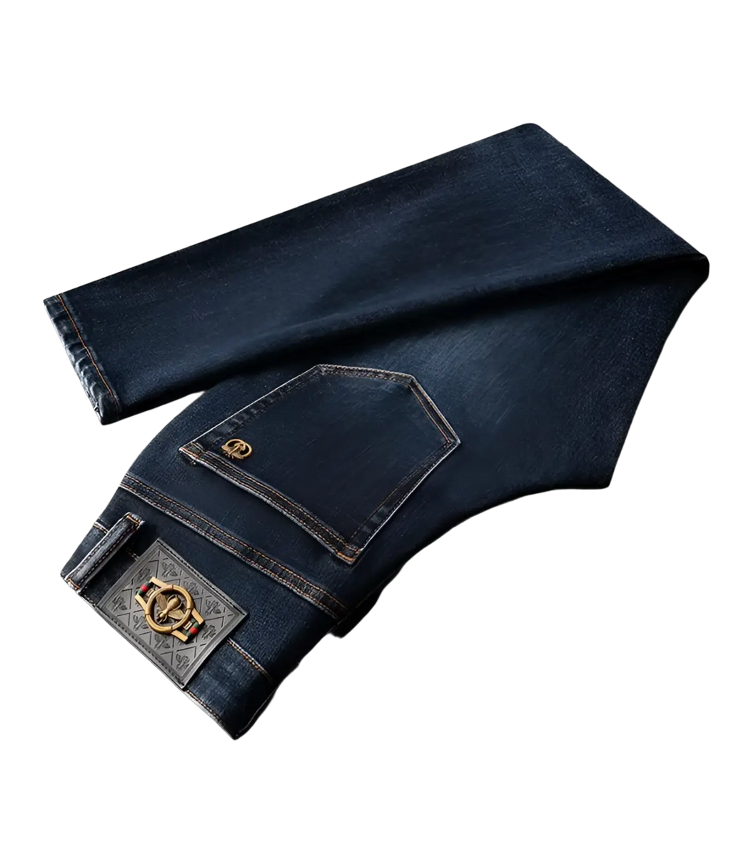 Back side of slim fit dark blue denim jeans men featuring gold-toned logo patch and ornate metallic brand plaque