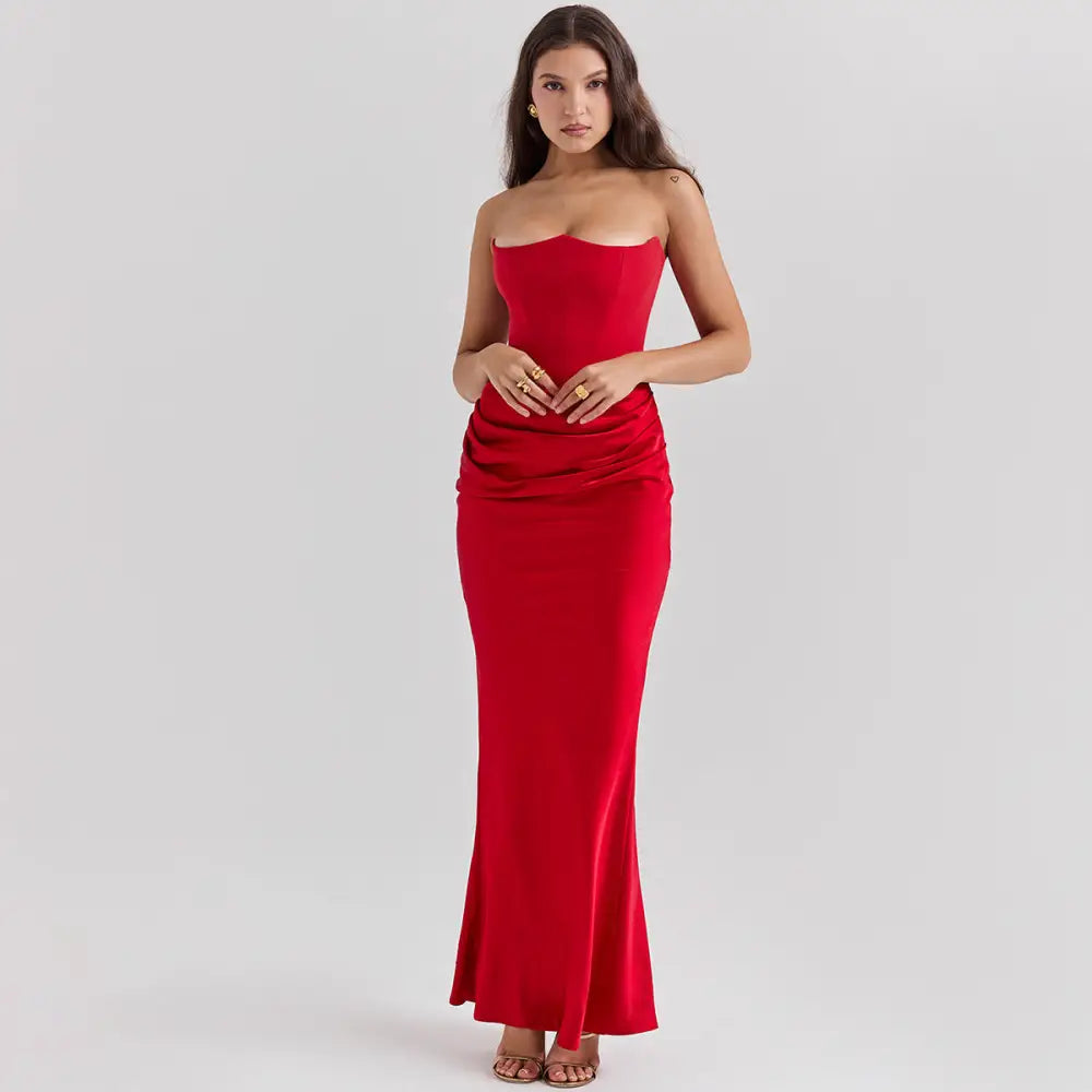 A sleek red satin strapless backless mermaid evening gown with a fitted bodice and flared skirt