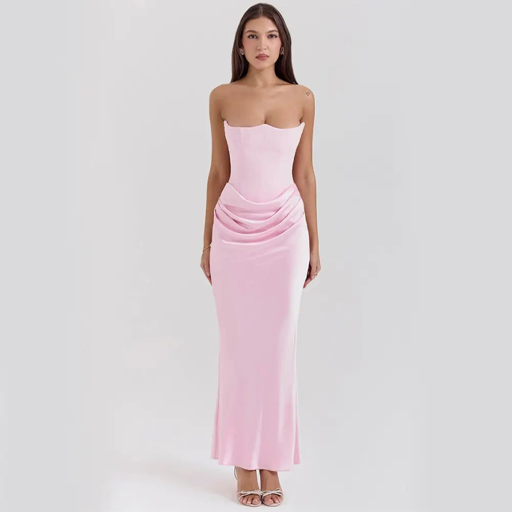 A soft pink satin strapless backless mermaid evening gown with a fitted bodice and flowing skirt