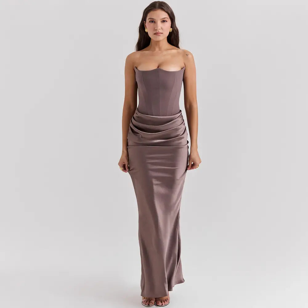 A sleek strapless backless mermaid evening gown in muted mauve satin with ruched waist detailing