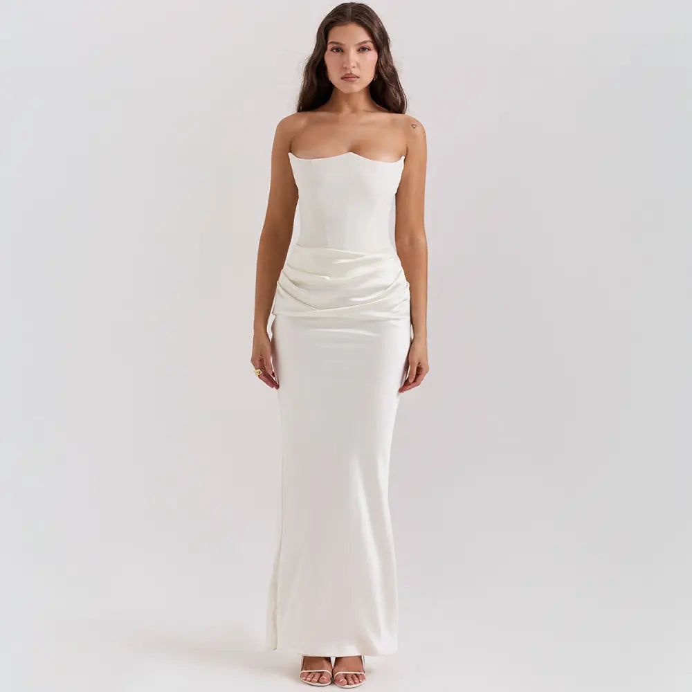 A sleek off-white satin strapless backless mermaid evening gown with a fitted bodice and flowing skirt