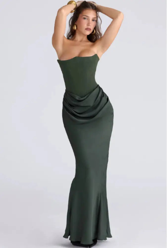 A sleek emerald green satin strapless backless mermaid evening gown with a draped waist detail