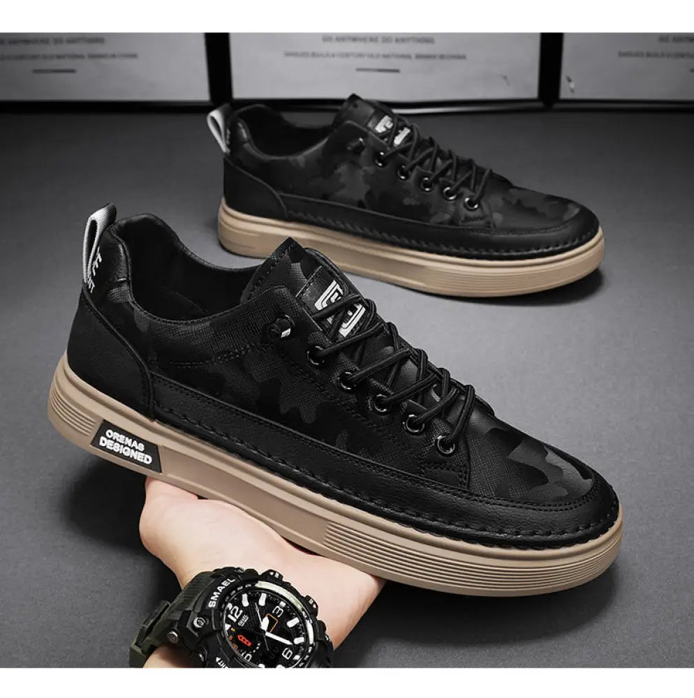 Men’s casual suede and leather slip-on sneakers in black camouflage with tan rubber sole and white stitching details