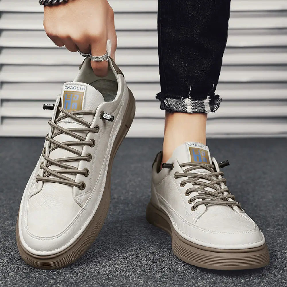 Men’s casual suede and leather slip-on sneakers in light gray with brown rubber soles and matching laces featuring a logo