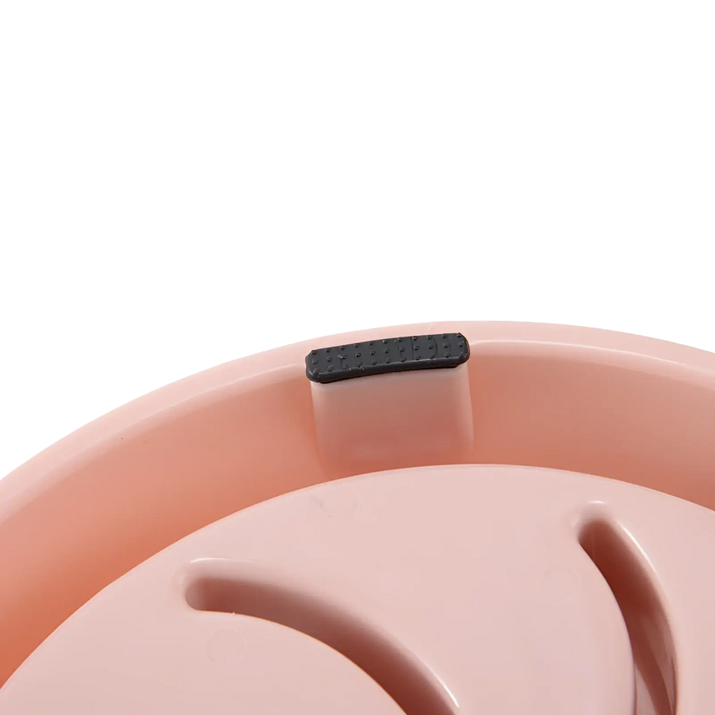 Pink plastic slow feeder dog bowl with black rubber grip rim designed as an anti choke pet dish