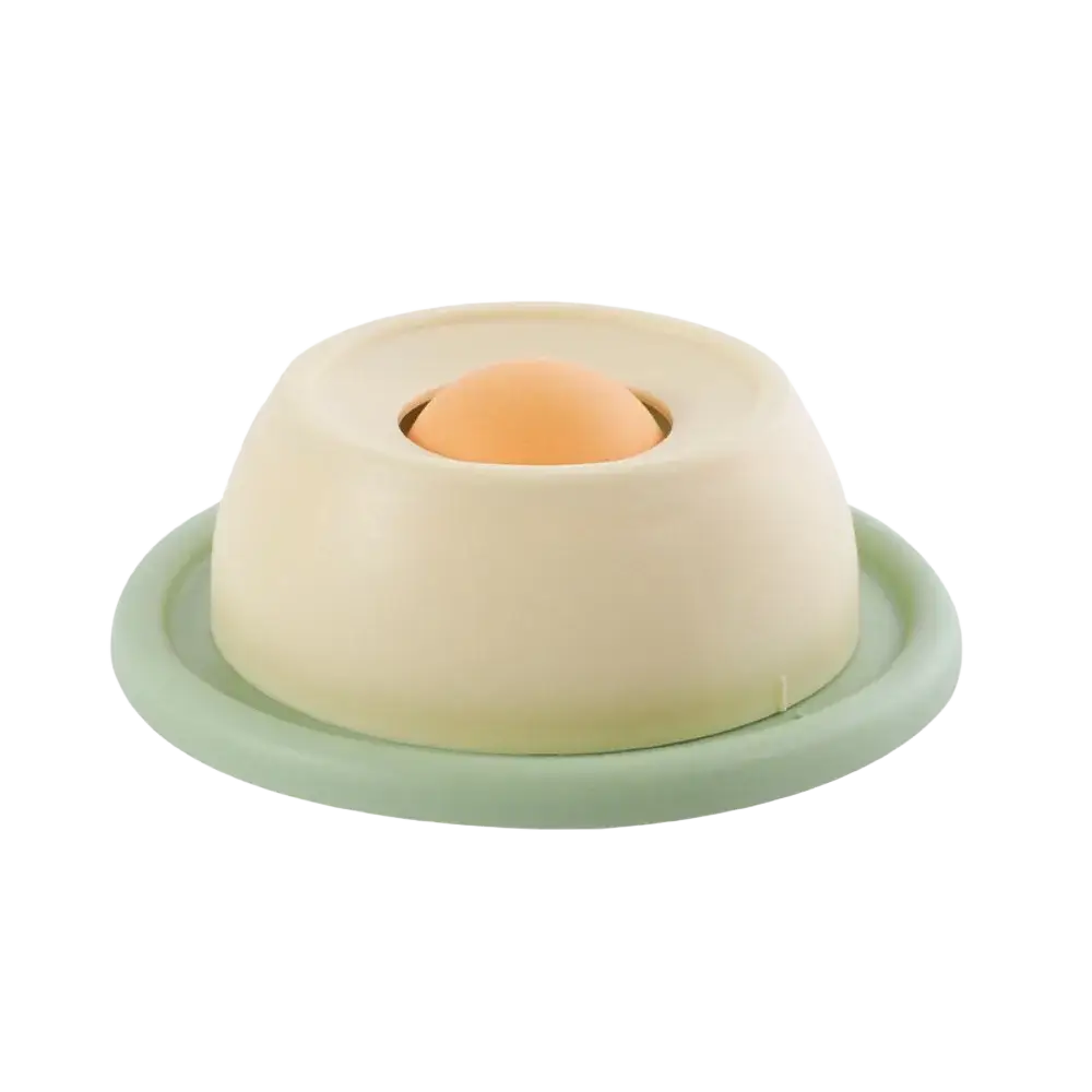 Cream-colored silicone slow feeder egg holder with light green stable base securely cradles an orange egg