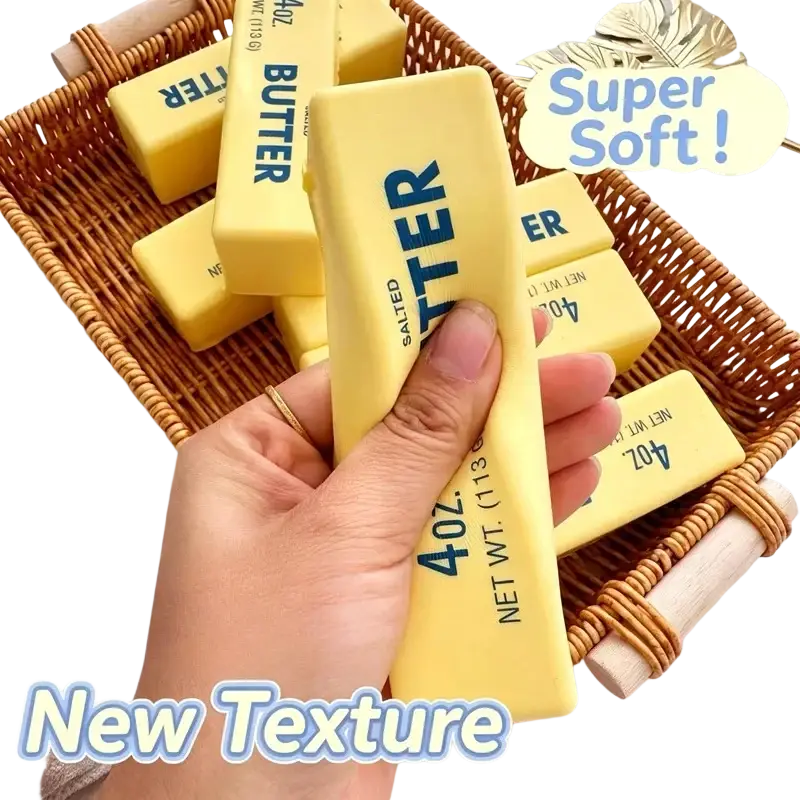A hand holds a bright yellow 4oz salted butter stick slow rising stress relief toy with blue text on smooth surface