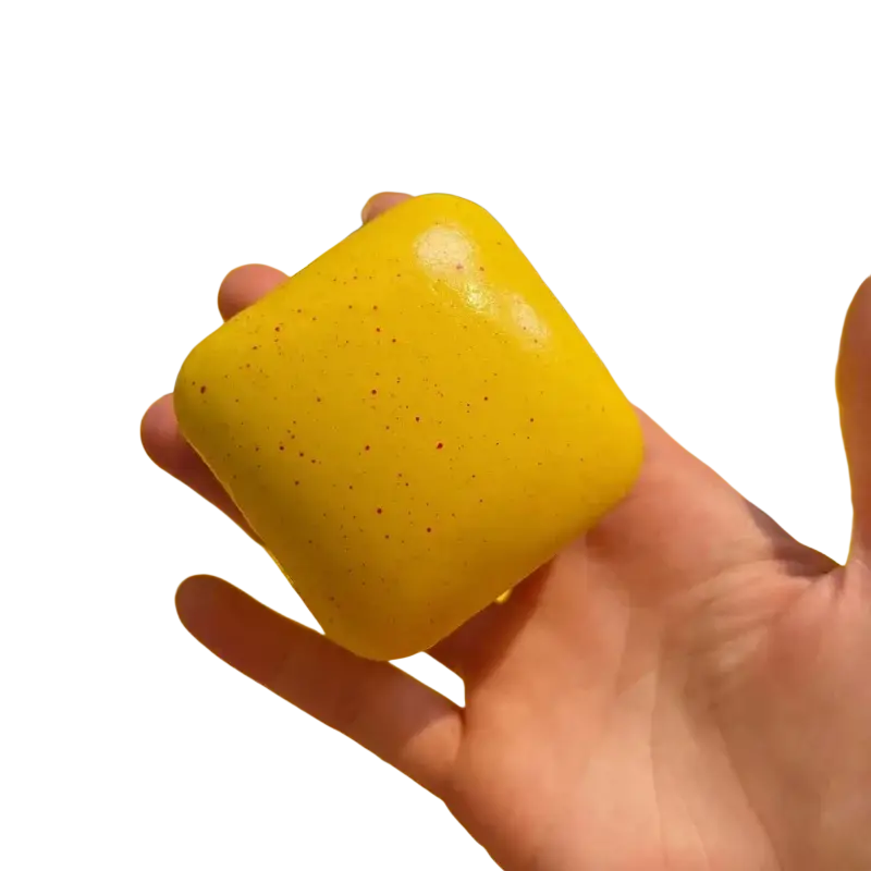 Bright yellow square mini toast slow rising squishy toy with glossy finish and tiny red speckles for fidget use