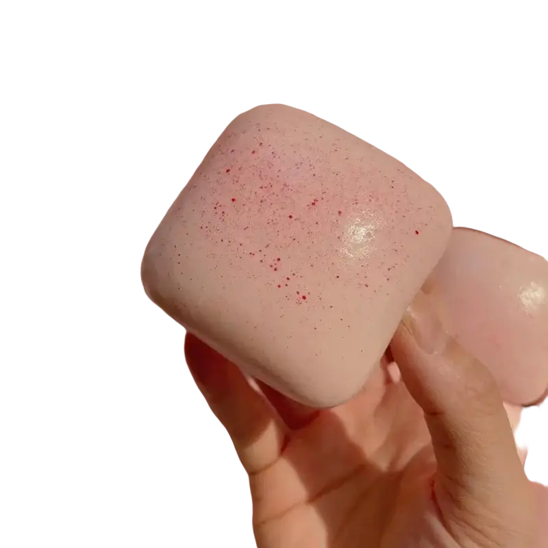 A soft pink square-shaped pinkberry mini toast slow rising squishy toy with a glossy finish and red speckles