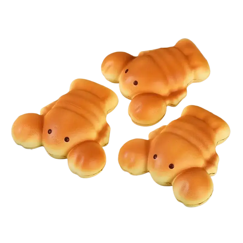 Three golden brown slow rising toast fidget toys with cute eyes on a wooden plate for stress relief and desktop decoration
