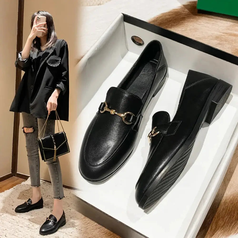 Black leather women’s loafers with gold-tone horsebit buckle and textured rubber soles