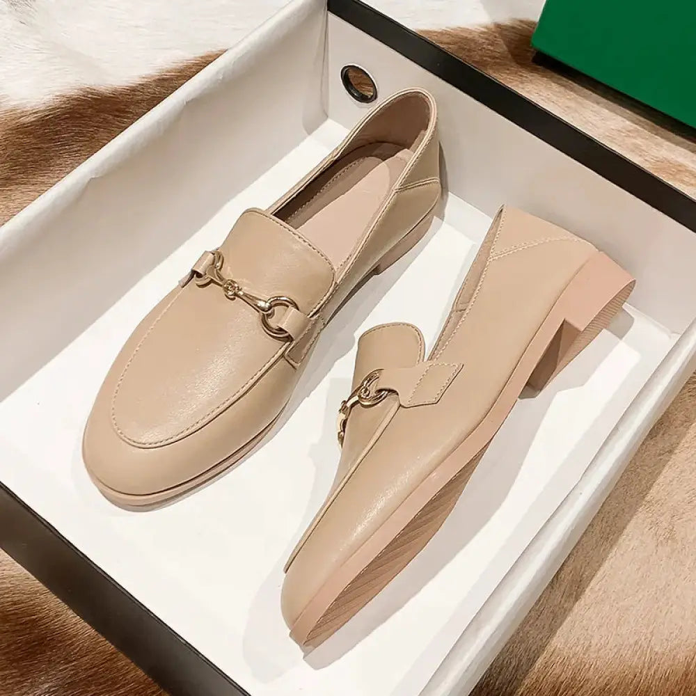 Beige leather women’s loafers with gold-tone horsebit buckle and low block heels for formal and casual wear