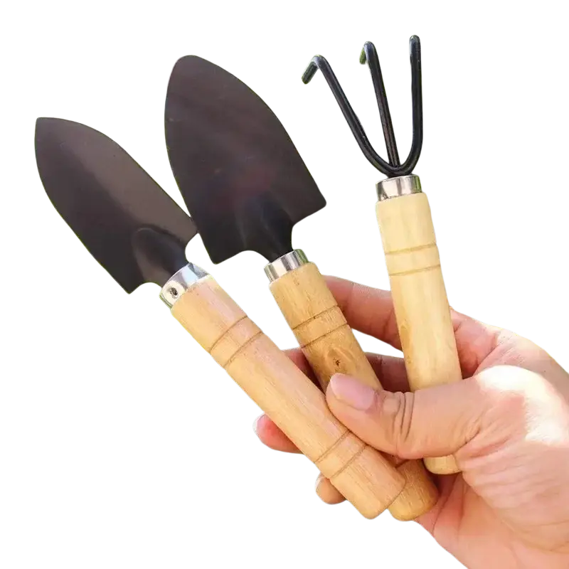 Set of three small gardening tools with light wood handles and black metal heads including garden shovel trowel and cultivator