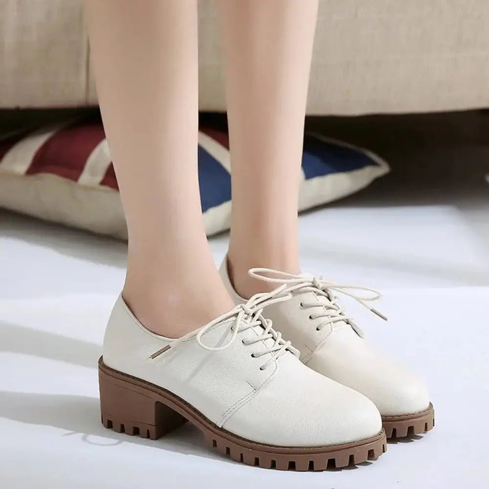 Cream-colored leather lace-up oxford shoes for women with chunky brown rubber sole