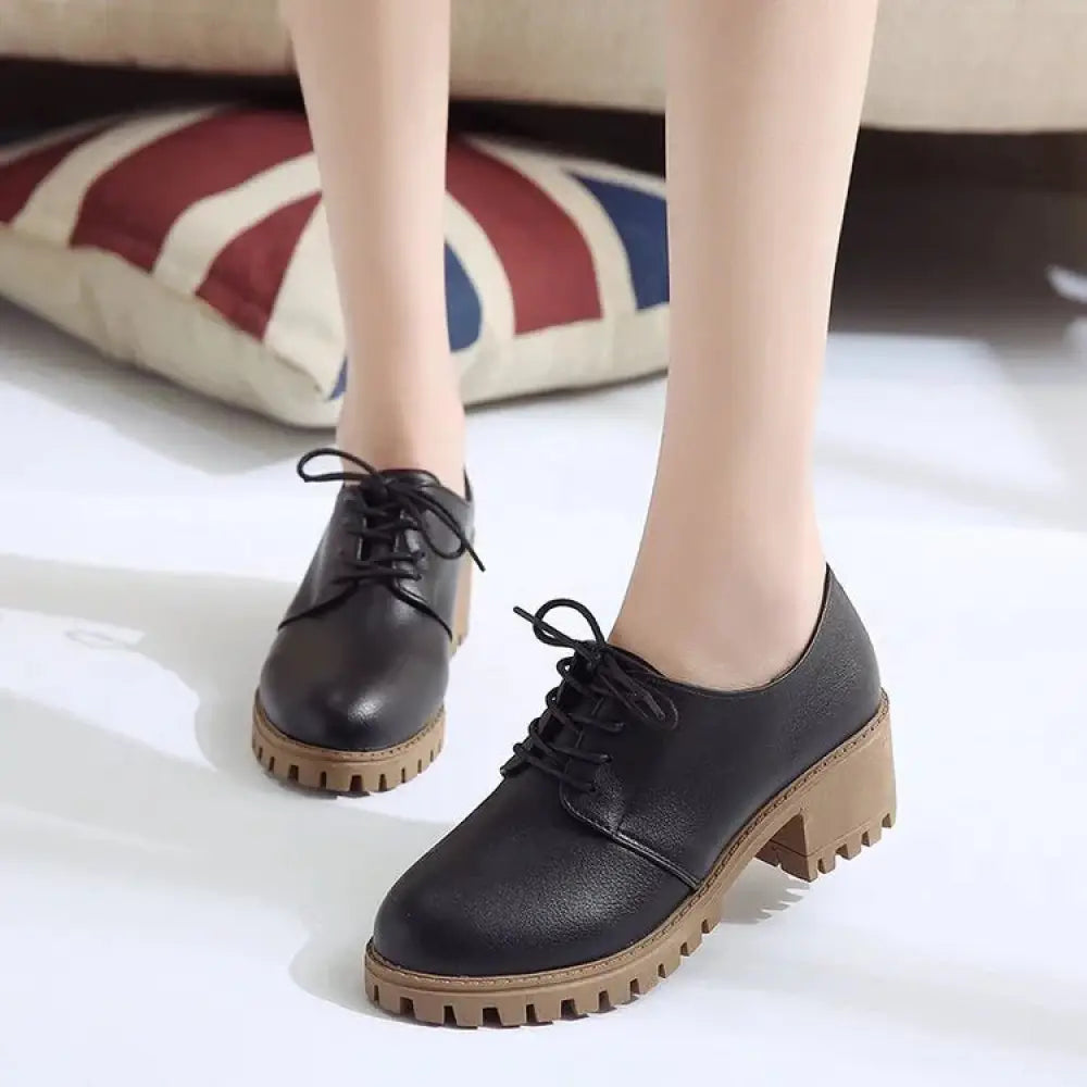 Black leather women’s lace up oxford shoes with chunky tan rubber sole and durable lace closure