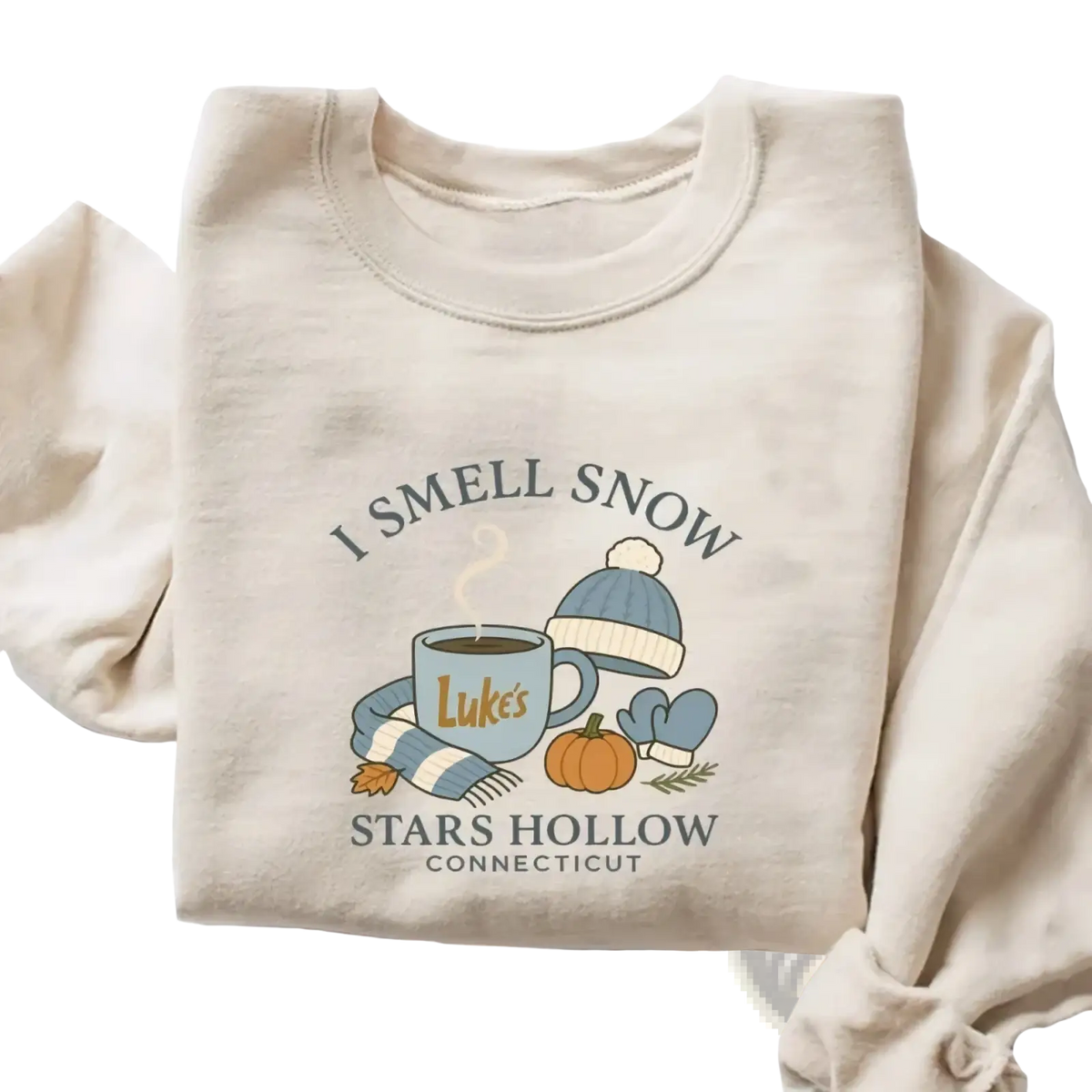Beige long-sleeved i smell snow christmas sweatshirt with cozy autumn-themed graphic of mug hat scarf and pumpkin