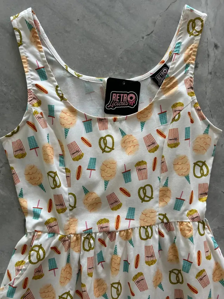 A white sleeveless vintage carnival snacks fit and flare cotton dress with green orange and teal snack patterns