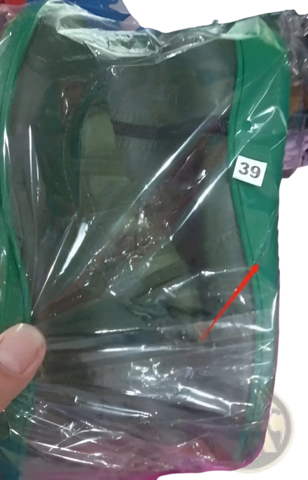 Green backpack covered with clear plastic bag sealed at top shown beside snake print wedge ankle boots for women