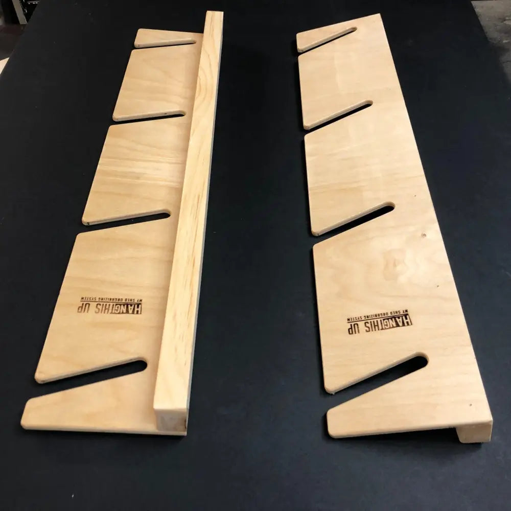 Light-colored wooden handcrafted minimalist snowboard wall mount display rack with engraved hang it up branding