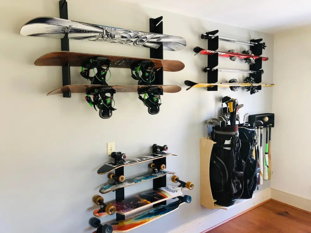 Black metal handcrafted minimalist snowboard wall mount display rack holding skis, snowboards, skateboards, and golf clubs