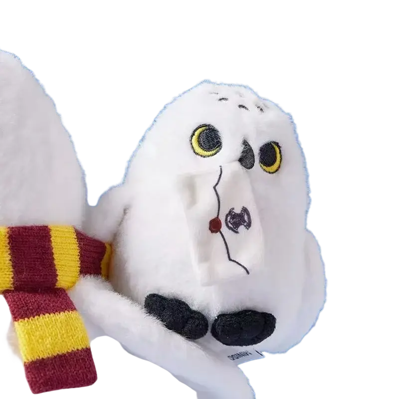 White plush snowy owl plush toy with yellow eyes black beak wearing a red and gold striped scarf