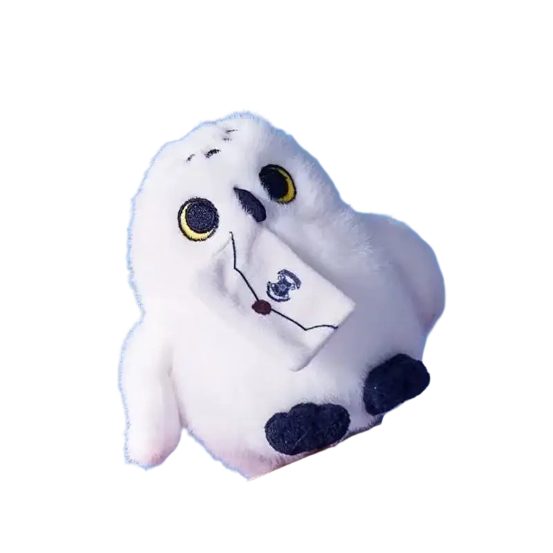 White plush snowy owl toy with yellow eyes black feet and scarf holding a small embroidered envelope