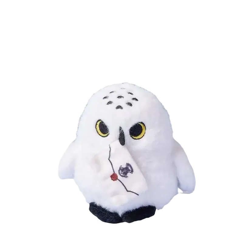 White plush snowy owl toy with yellow eyes black beak holding small embroidered letter and wearing scarf