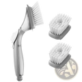 Gray plastic soap dispensing dish brush with white bristles and two interchangeable gray scrubber heads for cleaning