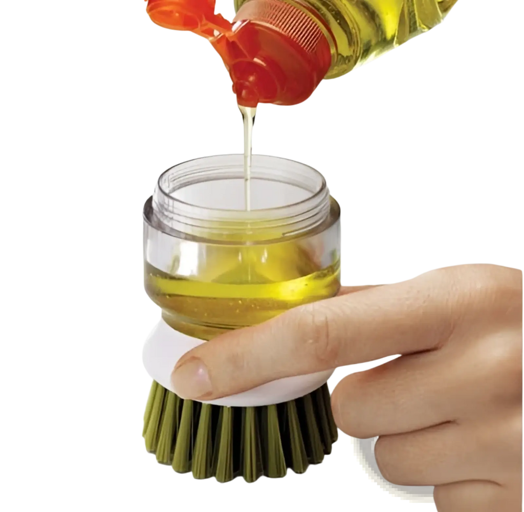 A clear glass soap dispensing dish brush with green bristles white base and yellow dish soap in a non slip storage base