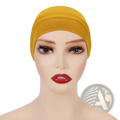 Soft cotton under scarf hijab cap in mustard yellow stretchy fabric worn snugly on a mannequin head